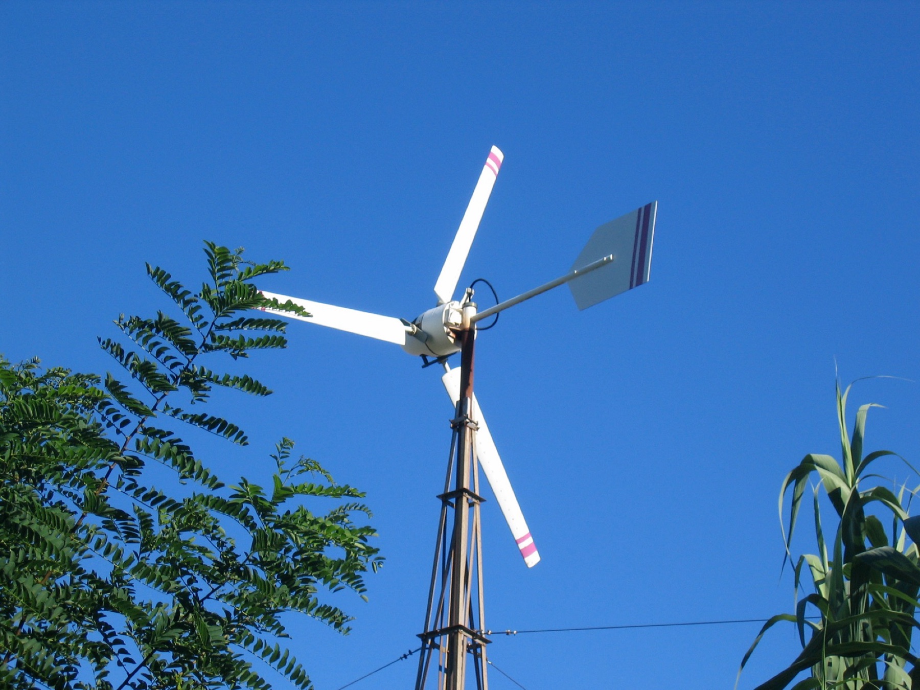 Kleinwindrad mit Windfahne vor blauem Himmel